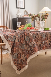 Detail of vintage bohemian tablecloth with jacquard weave and cream fringe tassels