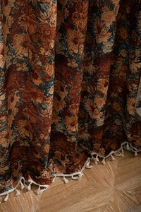 Close-up of vintage floral jacquard fabric with elegant cream fringe trim details