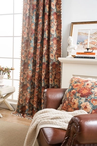 Detail of vintage floral jacquard curtains and matching pillows with elegant beige tassels