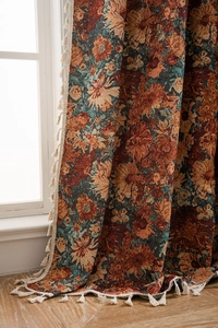 Close-up of thick floral jacquard curtain fabric with decorative white cotton tassels