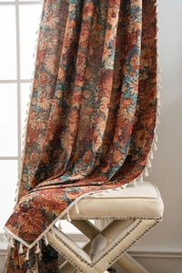 Close-up of vintage orange floral jacquard fabric with thick texture and white tassels