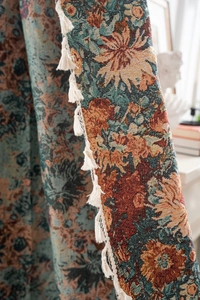 Macro detail of French jacquard floral fabric with hand-woven tassels for luxury home decor