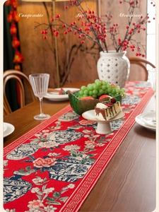 Detail view of red jacquard table runner with blue and white porcelain floral pattern