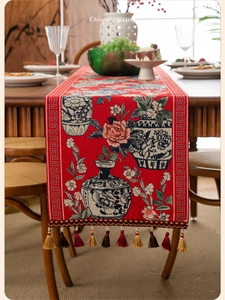 Detail of red Chinese style table runner with blue porcelain patterns and gold tassels