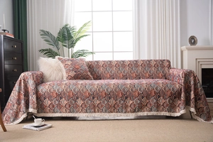 Detail of bohemian sofa cover featuring colorful jacquard patterns and delicate long tassels