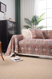 Detail view of jacquard sofa cover with fringe tassels and retro fan pattern