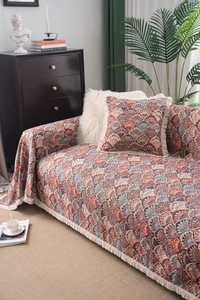 Detail of bohemian sofa cover with tassel fringe and jacquard shell pattern texture