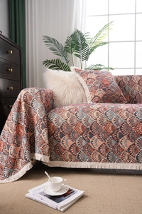Detailed close-up of Bohemian woven sofa cover with geometric patterns and fringe