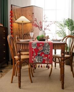 Detail of red jacquard table runner with blue and white porcelain pattern and tassels