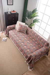 Close-up of bohemian jacquard sofa throw featuring retro shell patterns and white tassels