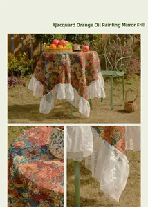 Detailed close-up of vintage orange floral jacquard tablecloth with white ruffle lace edges