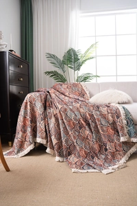 Bohemian woven throw blanket detail with orange-blue patterns and cream fringes