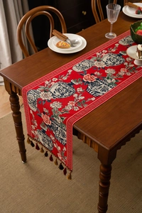 Detail of red jacquard table runner featuring classic blue and white porcelain floral motifs