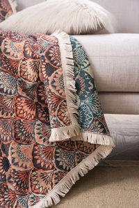 Close-up of bohemian jacquard sofa throw with ethnic patterns and beige fringes