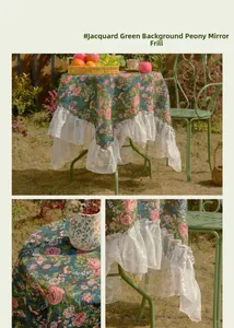 Detail of vintage green floral tablecloth with pink peonies and white lace ruffle edges