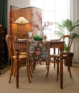 Détail de chemin de table marron café avec motifs pivoines en jacquard et glands élégants