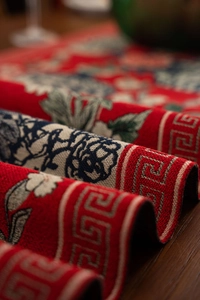 Macro shot of red jacquard table runner with peony patterns and vintage tassels