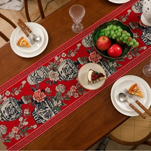 Red Chinese table runner with peony jacquard and tassels on a dark wood table