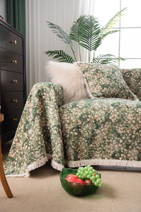 Detailed view of forest green floral jacquard sofa throw with elegant cotton fringe edges