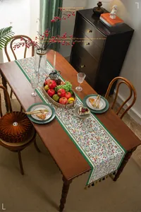 Detail of floral jacquard table runner with handmade woven tassels in vintage rustic style