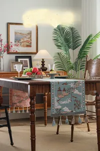 Detail of teal jacquard table runner with classical landscape patterns and elegant tassels
