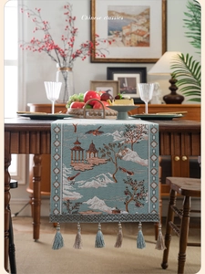 Detail of blue Chinese table runner featuring jacquard pavilion pattern and silk tassels