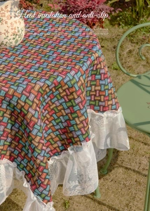 Macro shot of colorful woven jacquard tablecloth with white lace ruffle edge details