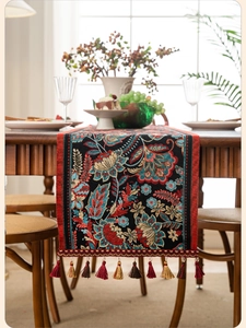 Detailed close-up of vintage floral jacquard fabric with tassels for dining table decor