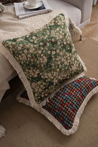 Detail of bohemian jacquard pillows with thick tassels and woven texture on a sofa