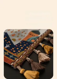 Dettaglio di nappe marroni e oro fatte a mano su un runner da tavola jacquard