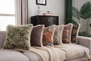 Detail of six American style jacquard decorative pillows with fringe edges on a sofa