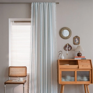 Rideau en coton et lin blanc avec motif en losange bleu sarcelle et bordure à glands