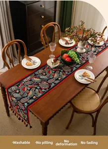 Macro detail of Jacquard table runner with vintage floral patterns and purple fringe tassels