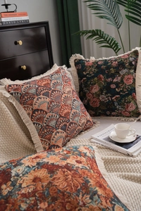 Detailed view of jacquard throw pillows with fringe edges in a vintage home setting