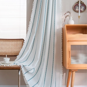 Rideau blanc à broderie géométrique à rayures avec pompons dans un style rustique