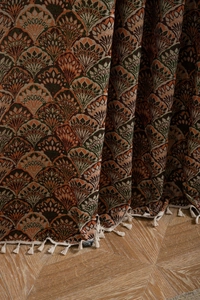 Detailed view of bohemian jacquard fabric with floral patterns and white cotton fringe