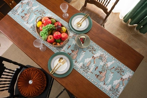 Close-up of a lake blue table runner with mountain, pavilion and bird patterns