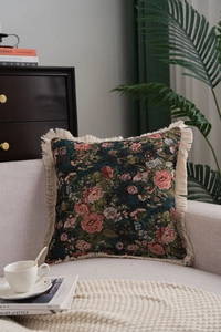 Macro detail of floral jacquard cushion with thick cream fringe in vintage living room