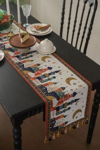 Dettaglio del runner da tavola jacquard con motivi architettonici e nappe decorative