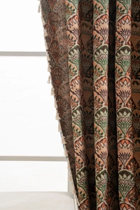 Detail of heavy jacquard curtain with retro floral geometric pattern and cream tassels