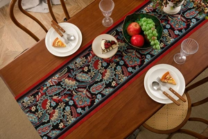 Detail of vintage jacquard table runner with intricate floral patterns on wooden table