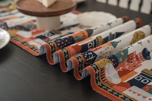 Dettaglio del runner da tavolo jacquard con motivo di città di cartone animato e stelle
