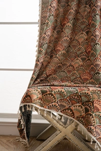 Close-up of retro jacquard fabric showing fan pattern texture and white fringe tassels