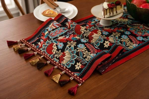 Detail of bohemian floral jacquard table runner with decorative multi-color tassels