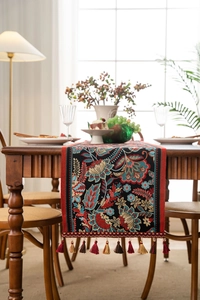Close-up of vintage floral jacquard table runner with decorative colorful tassels