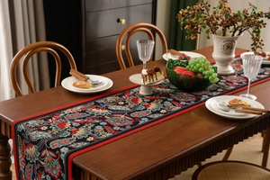 Close-up of bohemian floral jacquard table runner with red piping on a wooden dining table