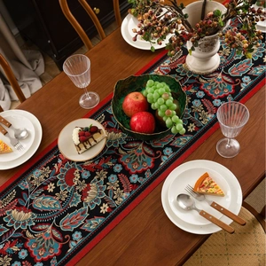 Ethnic retro jacquard table runner with red floral patterns on a dark wooden table
