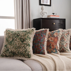 Jacquard throw pillows with fringe in floral and geometric patterns on a sofa