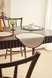 Detailed view of round cotton linen placemats with handmade crochet scalloped lace edging