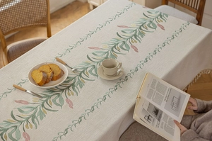 Detail der modernen cremefarbenen Tischdecke mit Blumenstickerei und Quastenbesatz